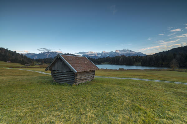 Wooden hut frames the alpine lake surrounded by the Alps Geroldsee Krün Garmisch Partenkirchen Upper Bavaria Germany Europe