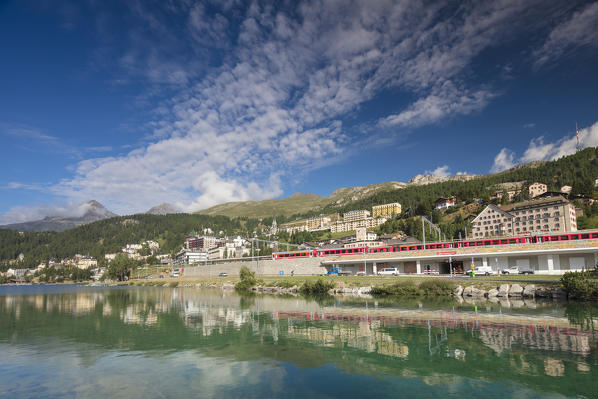 Bernina Express train runs across the village of St.Moritz surrounded by lake Canton of Graubünden Engadine Switzerland Europe
