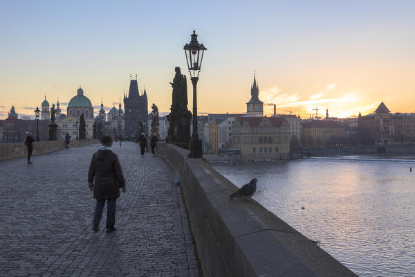 People on the historical Charles Bridge on Vltava (Moldava) river at dawn Prague Czech Republic Europe