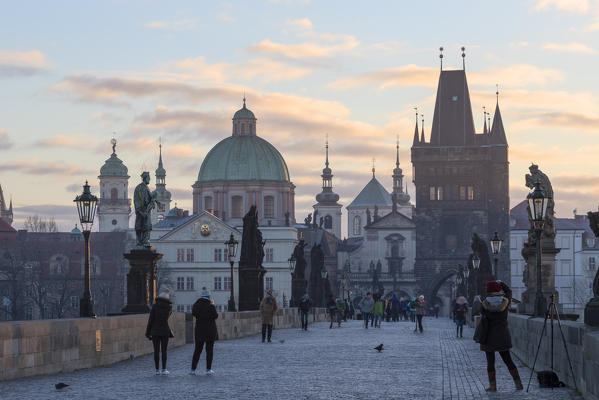People on the historical Charles Bridge on Vltava (Moldava) river at dawn Prague Czech Republic Europe