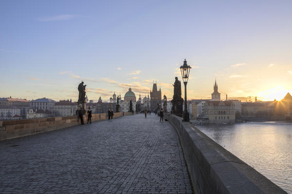 People on the historical Charles Bridge on Vltava (Moldava) river at dawn Prague Czech Republic Europe