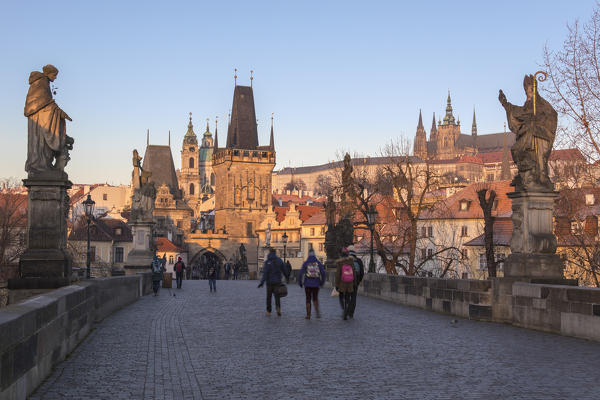 People on the historical Charles Bridge on Vltava (Moldava) river at dawn Prague Czech Republic Europe