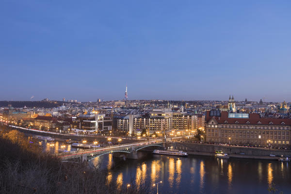 Dusk lights up the historical bridges and buildings reflected on Vltava (Moldava) river Prague Czech Republic Europe
