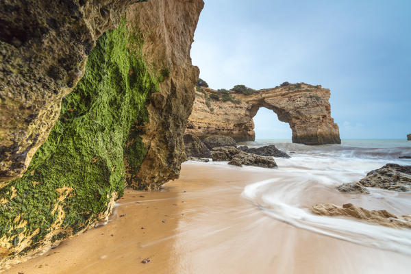 Waves crashing on the sand beach surrounded by cliffs Albandeira Lagoa Municipality Algarve Portugal Europe