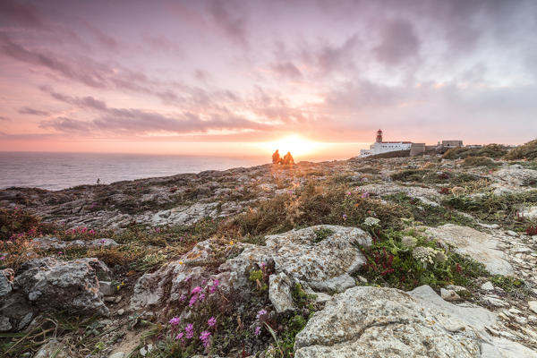Pink sky at sunset frames the lighthouse overlooking the Atlantic Ocean Cabo De Sao Vicente Sagres Algarve Portugal Europe