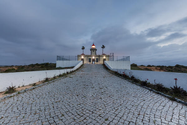 Dusk lights up the the lighthouse surrounded by the Atlantic Ocean Ponta Da Piedade Lagos Algarve Portugal Europe