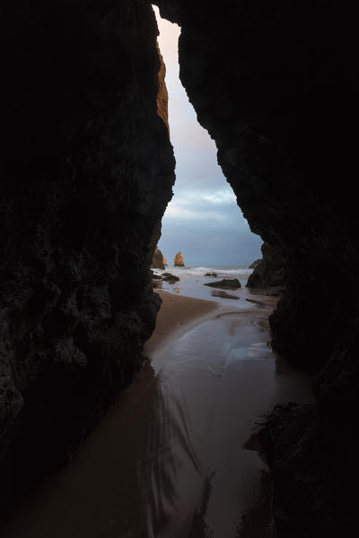 View of the sandy beach and ocean from a sea cave Praia Dos Tres Irmaos Portimao Algarve Portugal Europe