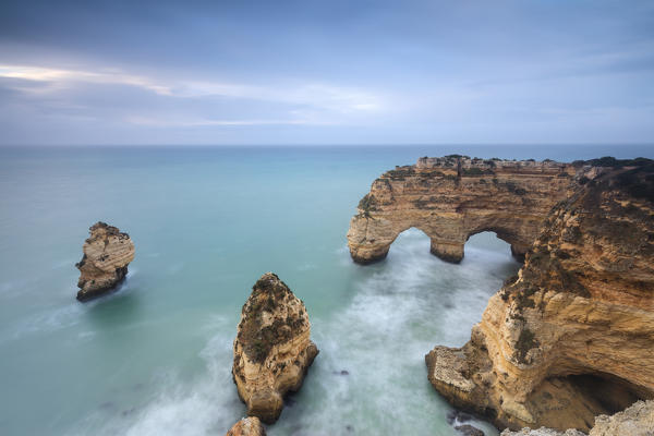 Rocky cliffs framed by turquoise water of the ocean Praia da Marinha Caramujeira Lagoa Municipality Algarve Portugal Europe