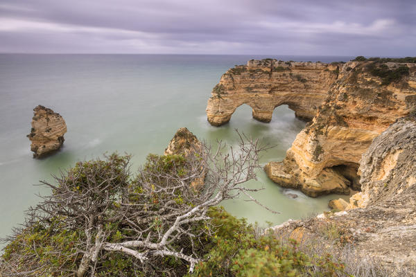 Dawn lights on cliffs framed by the turquoise ocean Praia da Marinha Caramujeira Lagoa Municipality Algarve Portugal Europe