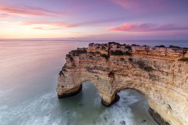 Sunrise on cliffs framed by turquoise water of the ocean Praia da Marinha Caramujeira Lagoa Municipality Algarve Portugal Europe