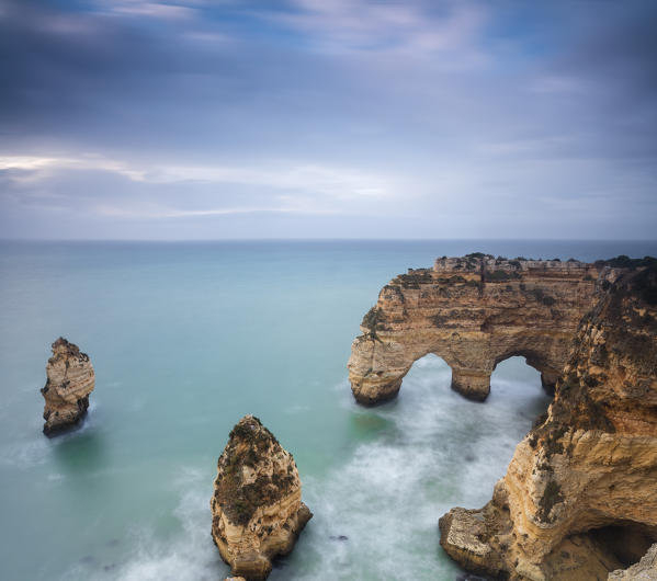 Panorama of cliffs framed by the turquoise ocean Praia da Marinha Caramujeira Lagoa Municipality Algarve Portugal Europe