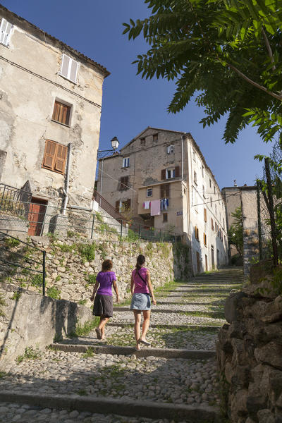 Tourists walk in the typical stone alleys of the old town of Corte Haute-Corse Corsica France Europe