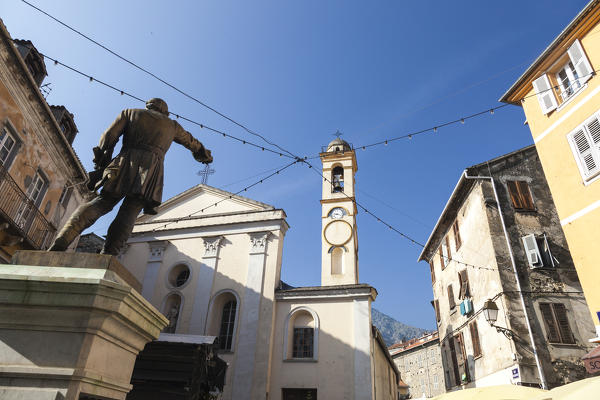 Blue sky and sun on the ancient church and statue of the old town Corte Haute-Corse Corsica France Europe