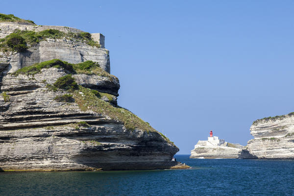 The Mediterranean blue sea frames the granite white cliffs and lighthouse Lavezzi Islands Bonifacio Corsica France Europe