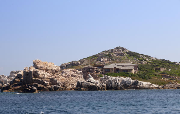 Blue sea frames granite rocks and a villa perched on the hill Lavezzi Islands Bonifacio Corsica France Europe