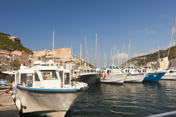 Boats moored in the harbor framed by the medieval old town and fortress Bonifacio Corsica France Europe