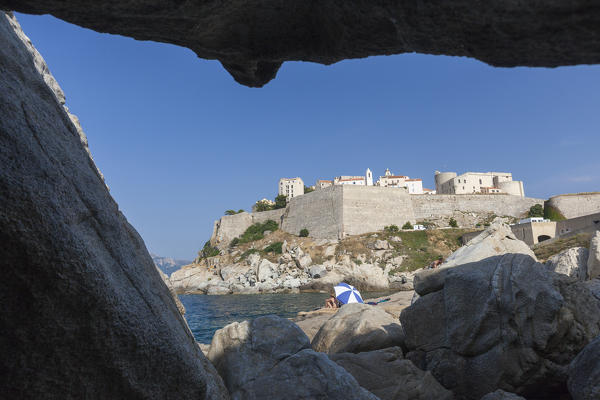 View of the ancient fortified citadel from a sea cave Calvi Balagne Region northwest Corsica France Europe