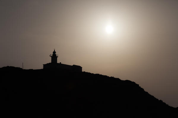 Silhouette of La Pietra Lighthouse at sunset Ile Rousse Balagne Region Corsica France Europe