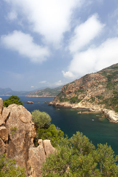 Clouds and blue sky on the blue sea surrounded by granite cliffs and plants Porto Southern Corsica France Europe