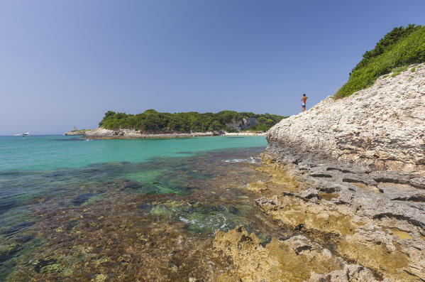 Tourist on the limestone cliffs admires the turquoise sea Sperone Bonifacio South Corsica France Europe