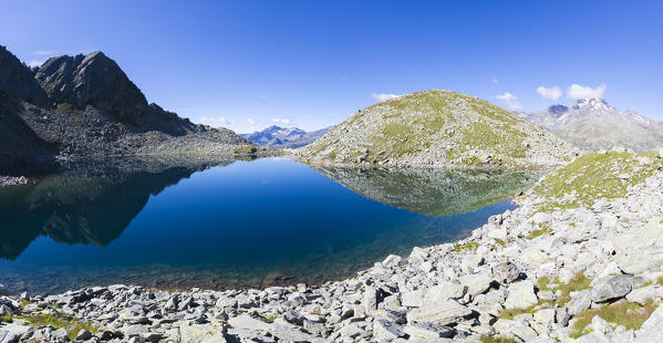 Panorama of rocky peaks reflected in the clear waters of Lago Nero in summer Chiavenna Valley Valtellina Lombardy Italy Europe