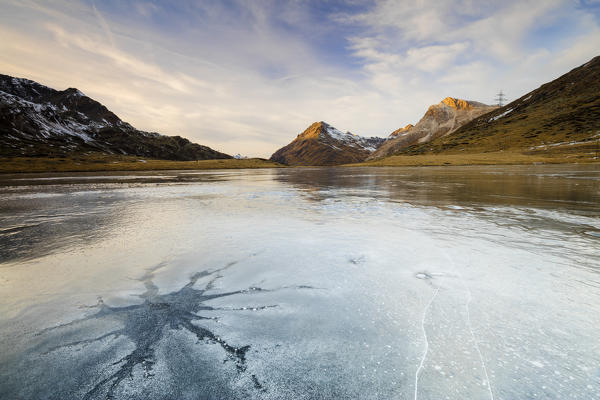 Sunset on the frozen Lej Nair surrounded by rocky peaks Bernina Pass Canton of Graubünden Engadine Switzerland Europe