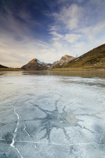 Sunset on the frozen Lej Nair surrounded by rocky peaks Bernina Pass Canton of Graubünden Engadine Switzerland Europe