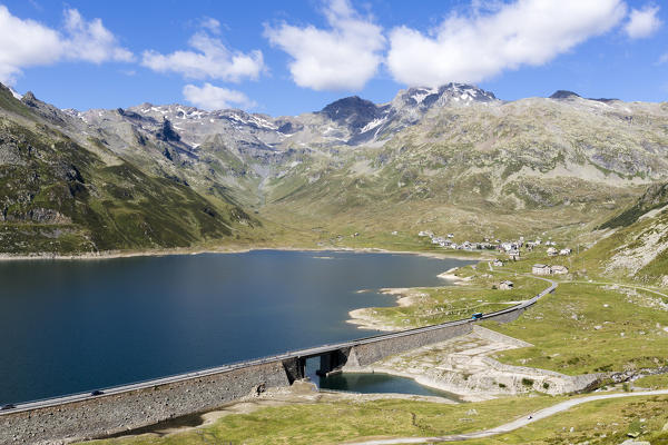 The rocky peaks frame the dam surrounding the blue Lake Montespluga in summer Chiavenna Valley Valtellina Lombardy Italy Europe