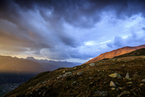 Dark clouds and sunset lights frame the rocky peaks of Muottas Muragl St.Moritz Engadine Canton of Graubünden Switzerland Europ