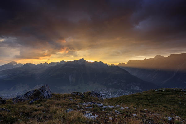 Fiery sky and dark clouds on high peaks of Muottas Muragl at sunset St.Moritz Engadine Canton of Graubünden Switzerland Europe