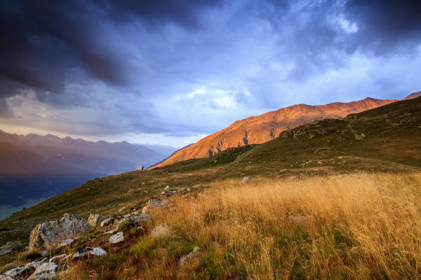 Dark clouds and sunset lights frame the rocky peaks of Muottas Muragl St.Moritz Engadine Canton of Graubünden Switzerland Europ