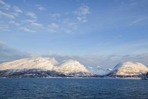 Blue sky on the snowy peaks surrounded by frozen sea Olderdalen Kafjorden Lyngen Alps Tromsø Norway Europe