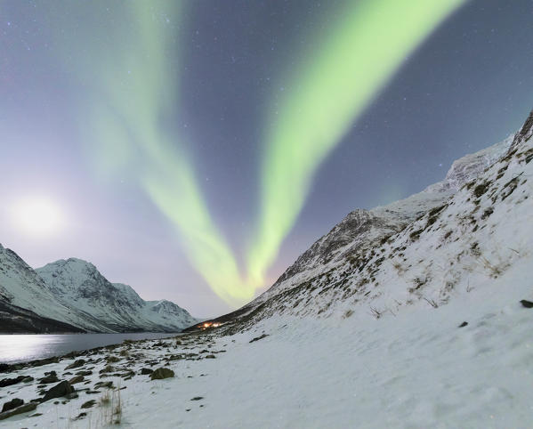 Panorama of the snowy Lyngseidet mountain illuminated by the Northern Lights and stars Lyngen Alps c Norway Europe