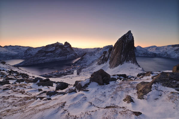 View of Mount Segla from peak Hesten with village of Fjordgard on left in Ornfjorden and Mefjorden on right Senja Norway Europe