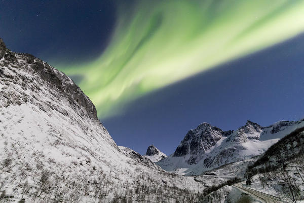 Northern lights and stars on the snowy peaks along the  National Tourist Route Bergsbotn Senja Tromsø Norway Europe