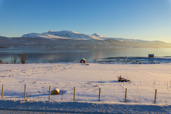 Wooden hut in the snowy landscape facing the cold sea on the road leading from Gibostad to Finnsnes Senja Tromsø Norway Europe