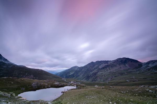 Laghetto Alto Scorluzzo framed by pink clouds at dawn Bormio Braulio Valley Valtellina Lombardy Italy Europe