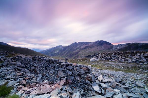 Pink clouds at sunrise frame the war trenches on rocky peaks Braulio Valley Stelvio Pass Valtellina Lombardy Italy Europe