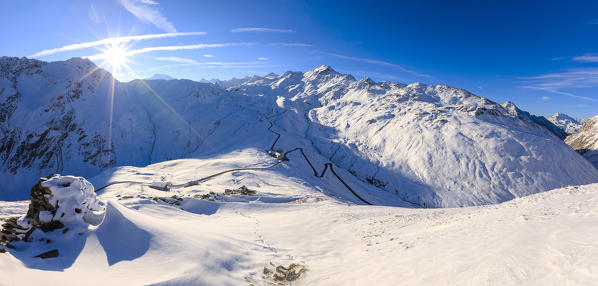 Panorama of the snowy landscape and the hairpin turns of Stelvio Pass at dawn Braulio Valley Valtellina Lombardy Italy Europe