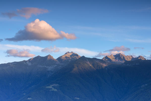 Pink clouds and blue sky lights up the rocky peaks of the Rhaetian Alps at dawn Valtellina Lombardy Italy Europe