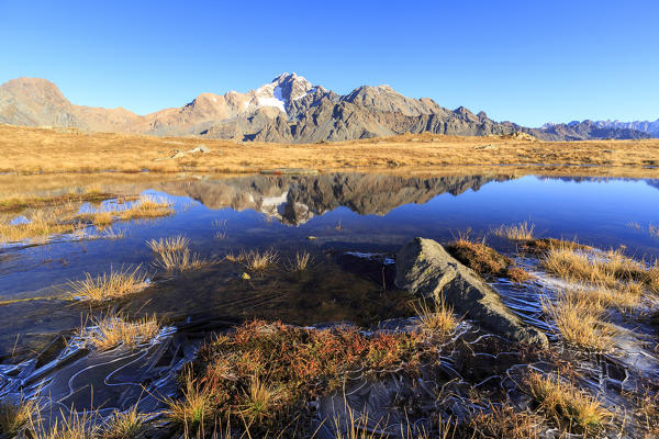 Rocky peaks of Mount Disgrazia are reflected in the alpine lake Val Torreggio Malenco Valley Valtellina Lombardy Italy Europe
