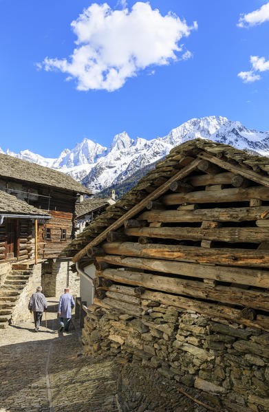 Elderly men between typical wood houses of Soglio Maloja canton of Graubunden Engadin Bregaglia Valley Switzerland Europe