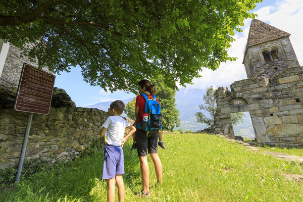 Mother and sons at the medieval Abbey of San Pietro in Vallate Piagno Sondrio province Lower Valtellina Lombardy Italy Europe