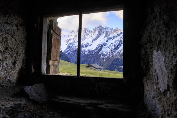 View of green meadows at dawn from abandoned stoned hut Tombal Soglio Bregaglia Valley canton of Graubünden Switzerland Europe