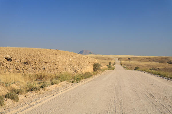 Road in the arid land leading to the Sesriem Area close to Naukluft Mountains Namib Desert Namibia Southern Africa