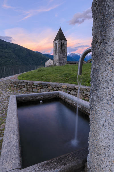 Stone fountain next to bell tower, Xenodochio of Santa Perpetua, Tirano, province of Sondrio, Valtellina Lombardy, Italy, Europe