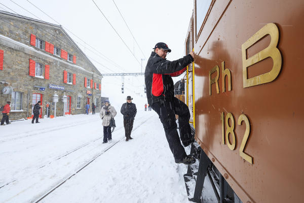 Man at work on the snowplow of Bernina Express train, Ospizio Bernina, Poschiavo, canton of Graubünden, Engadin, Switzerland