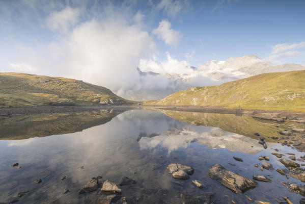 Clouds reflected in alpine lake, Bernina Pass, Poschiavo Valley, canton of Graubünden, Engadine, Switzerland