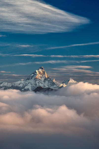 The massive Matterhorn emerging out of the clouds at sunrise. Next to it, another majestic peak, the Weisshorn - from one of the peak in the Mont Avic natural park, Alps, Aosta Valley, Italy Europe