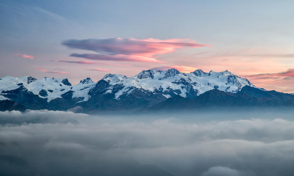 The sunrise lights coloring the Mount Rosa range, from its highest peak, Punta Dufour, to the Gnifetti, Nordend, Parrot and Zumstein - Mont Avic natural park,  Alps, Aosta valley, Italy Europe